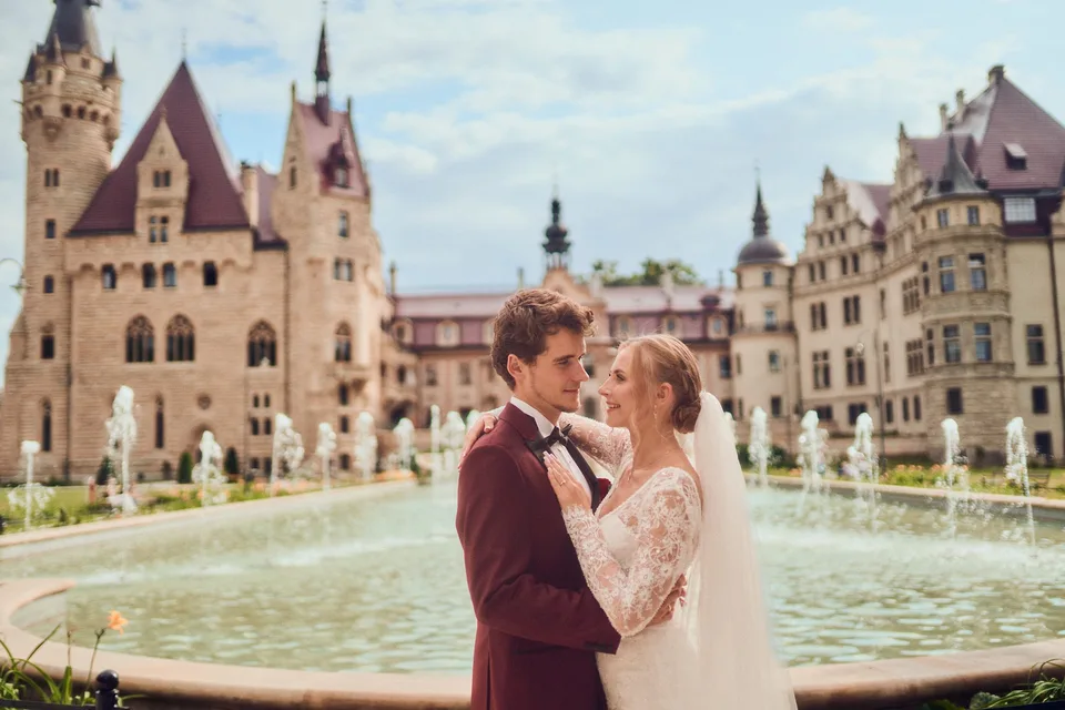 Para młoda przy fontannie, w tle zamek