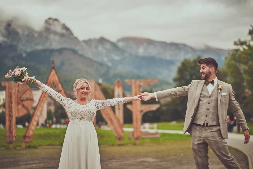Para młoda z rozłożonymi rękami przed Tatrami i napisem Zakopane